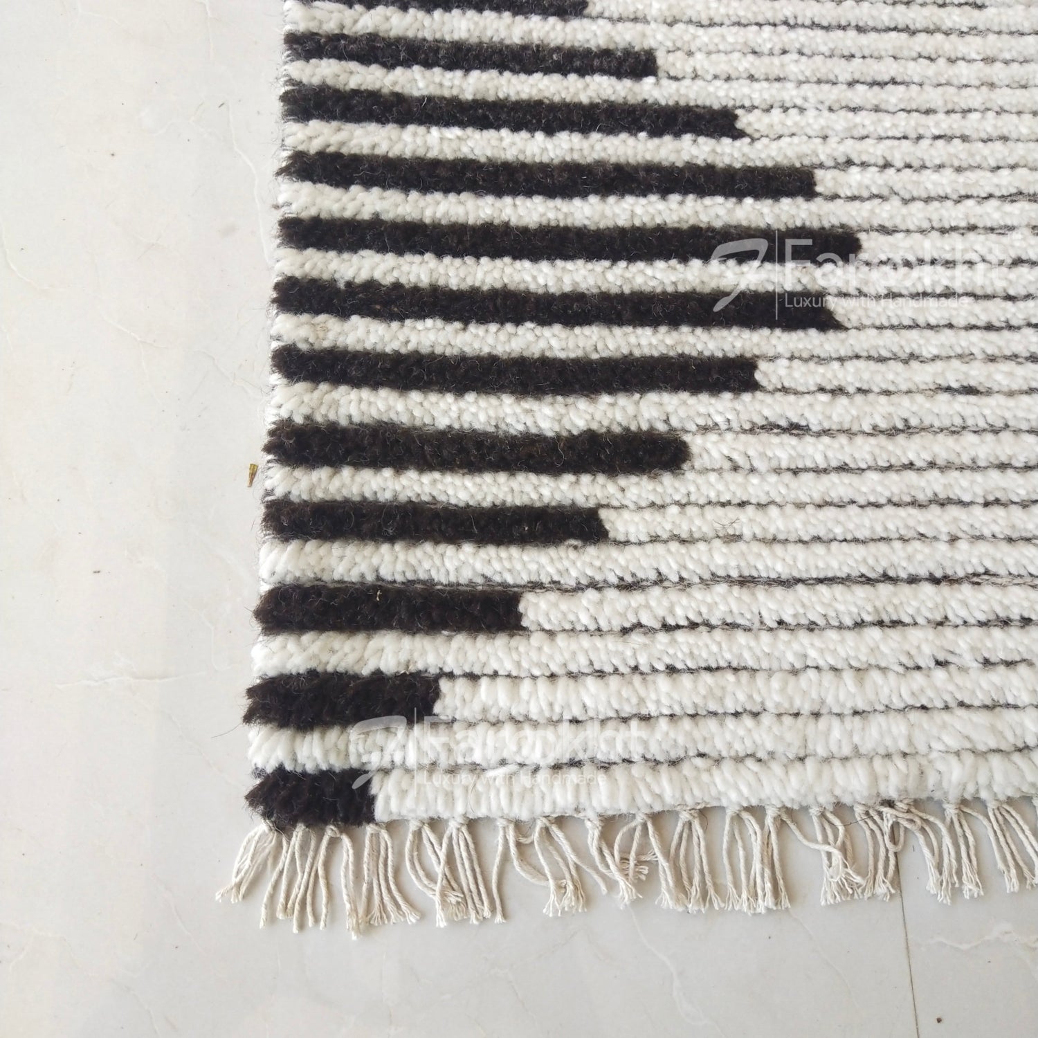 Black and white striped rug with fringe on a light gray floor