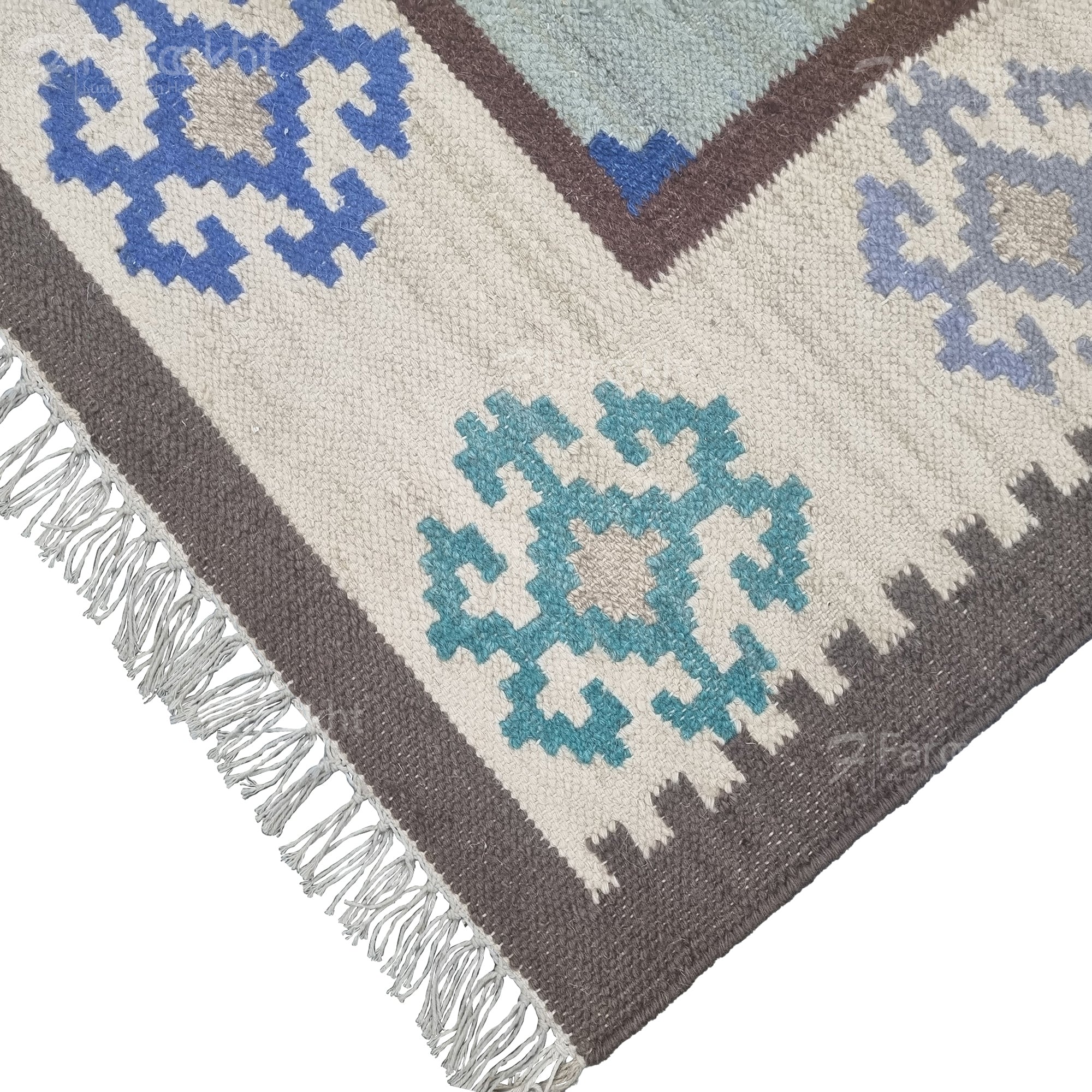 Close-up of a patterned rug with geometric designs in blue, gray, and white.