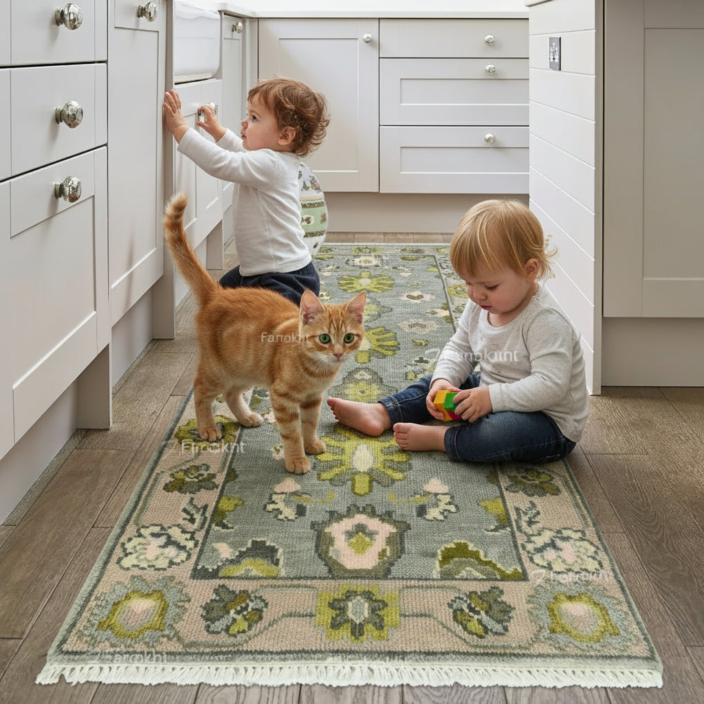 Two children playing with a cat on a patterned rug in a kitchen.
