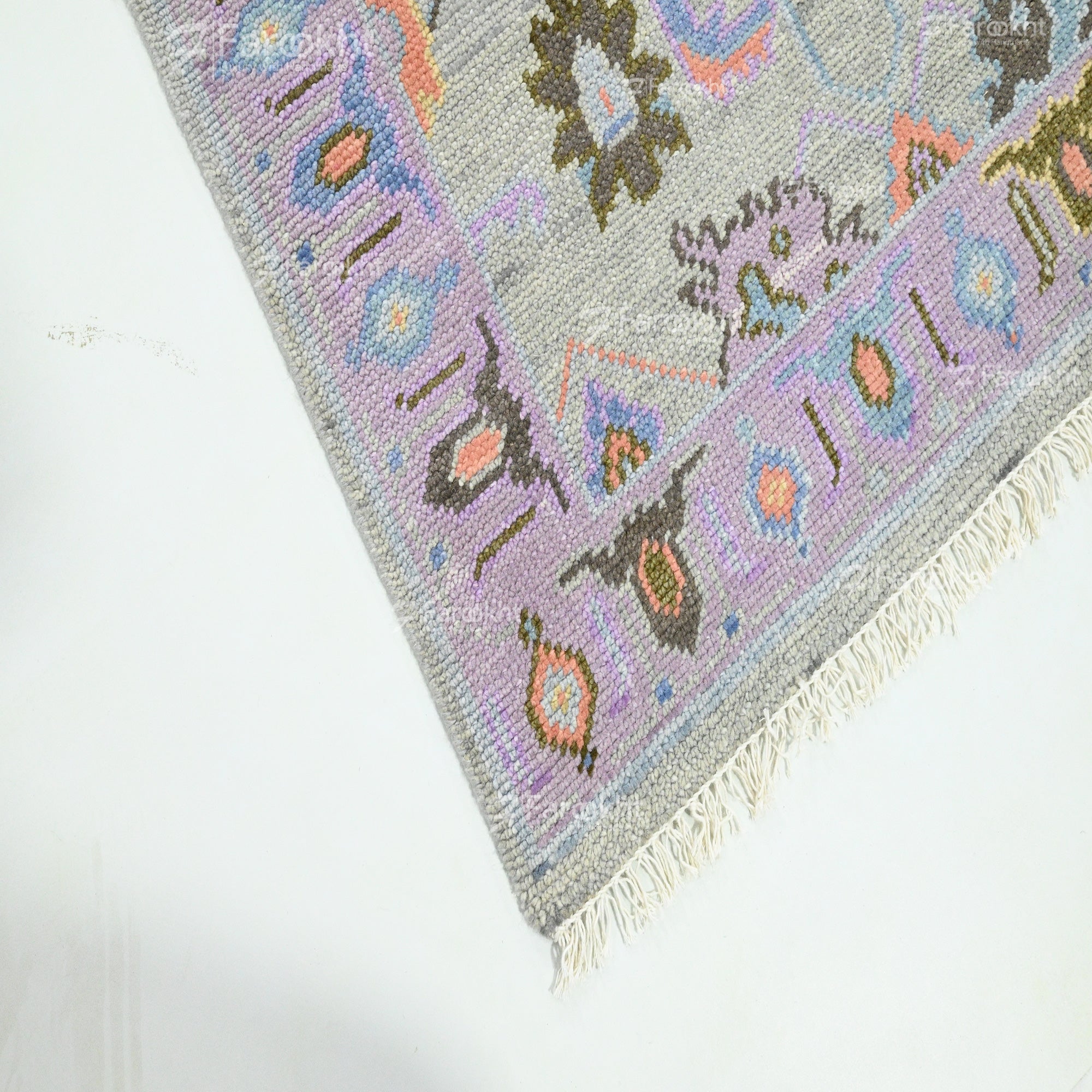 light grey soft rug with pastel border patterns