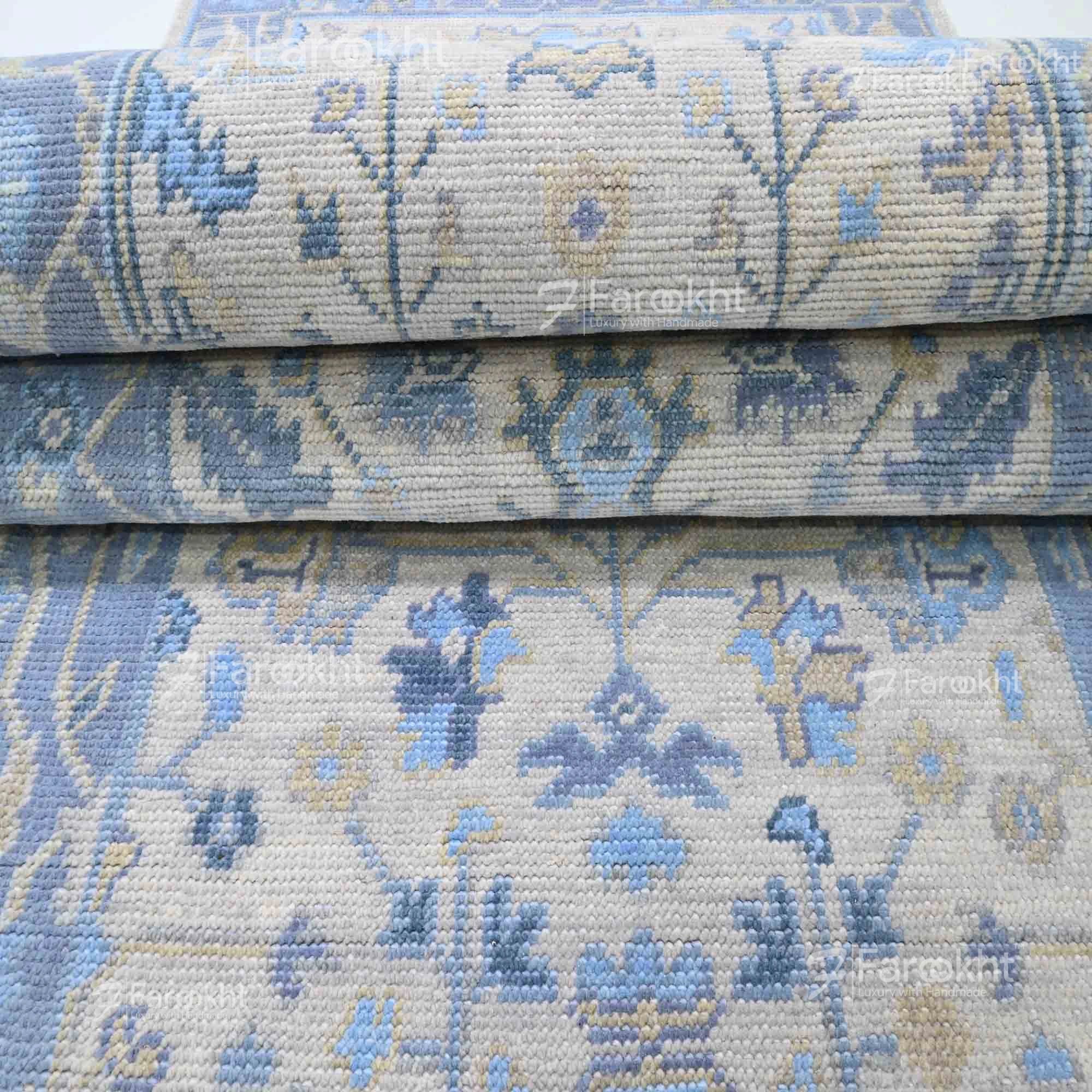 Stack of blue and beige patterned rugs with &