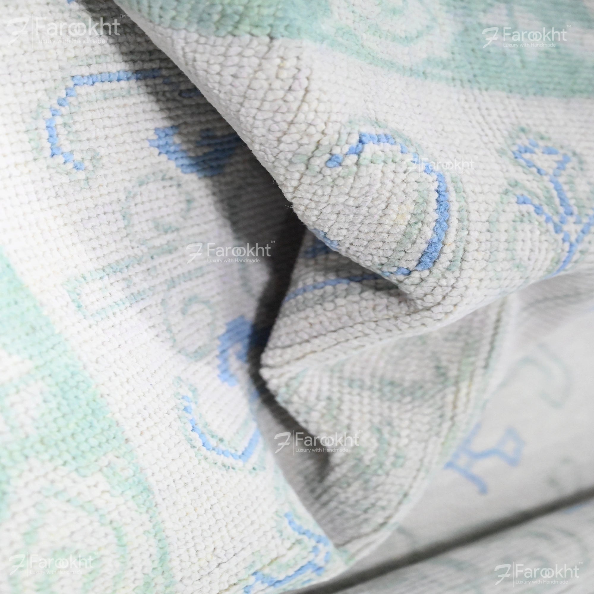 Close-up of a textured fabric with blue and green patterns, branded &