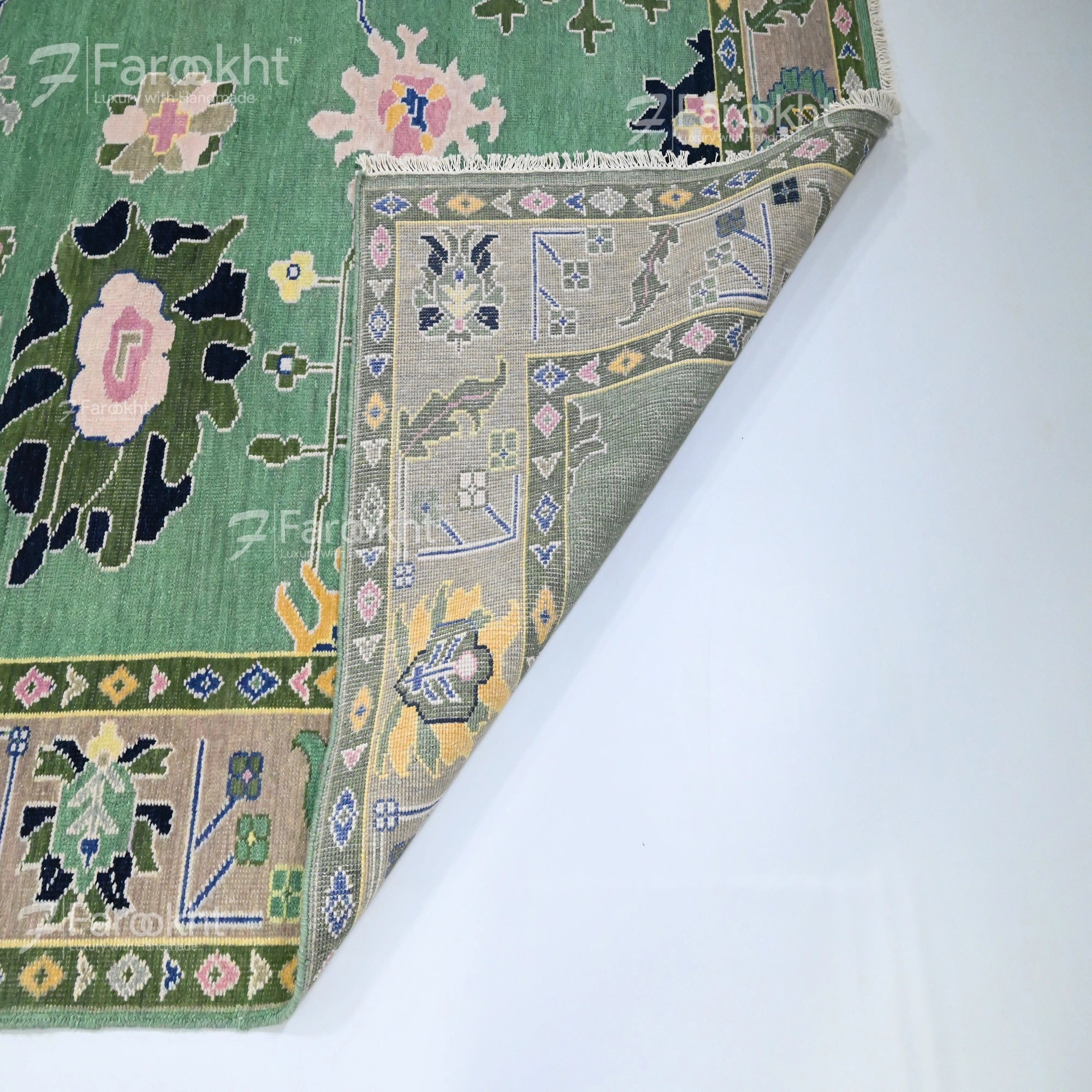 Close-up of a patterned rug with floral and geometric designs on a white background.