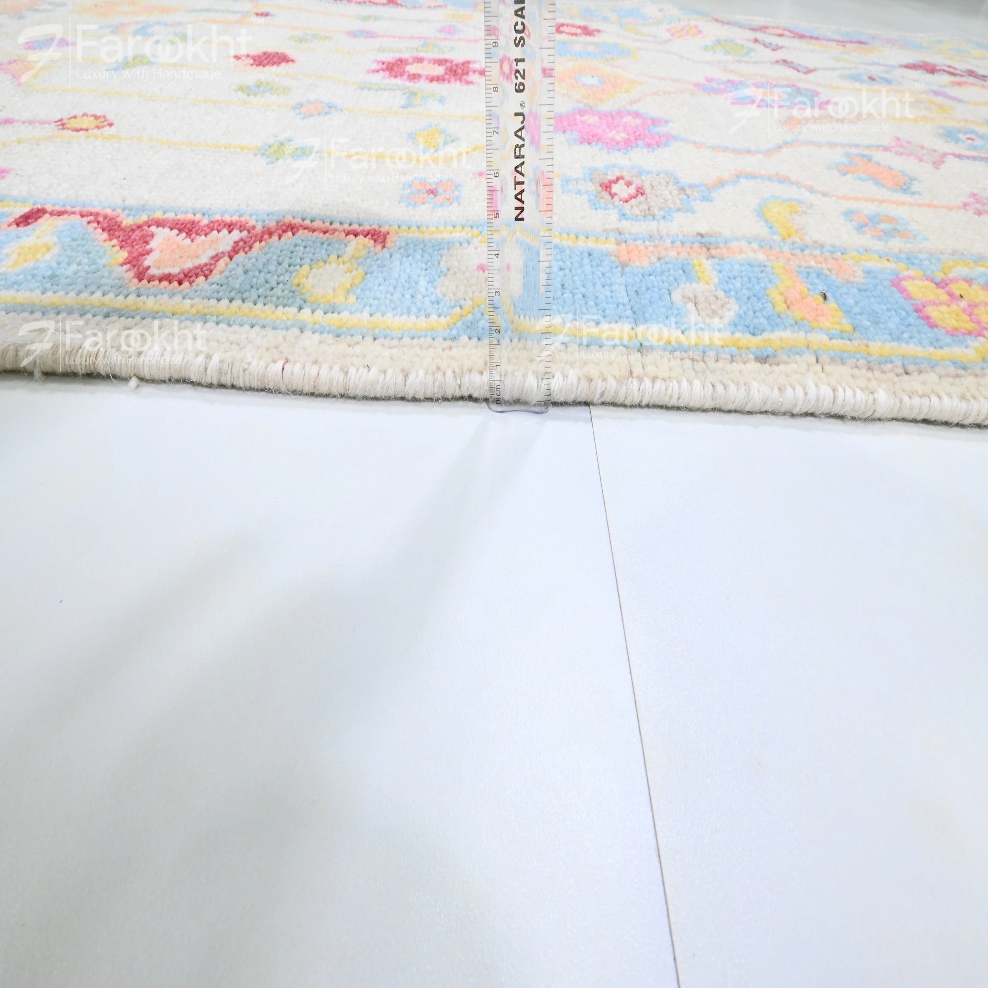 Close-up of a colorful rug with floral patterns on a white floor.
