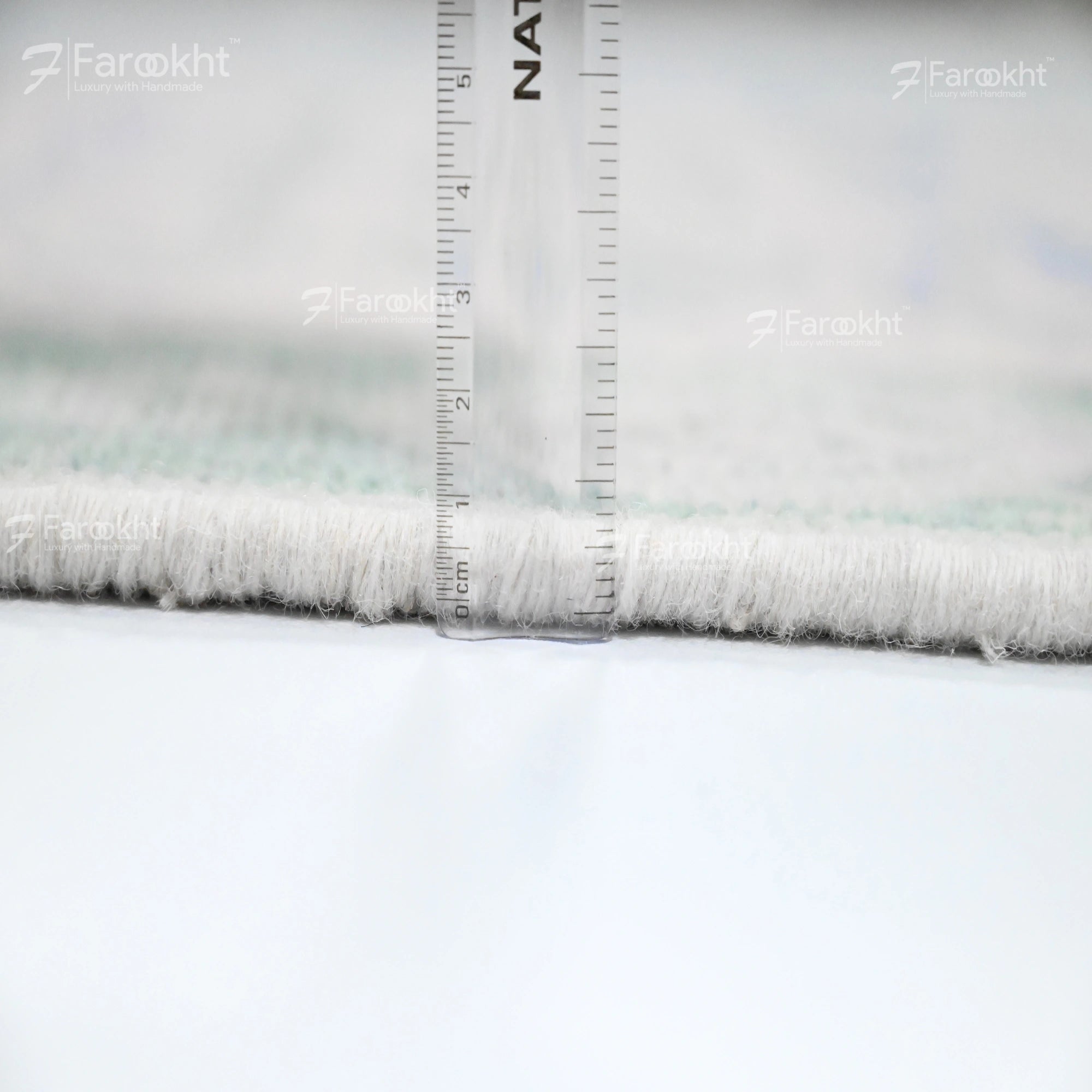 Close-up of fabric with a ruler for scale, branded &