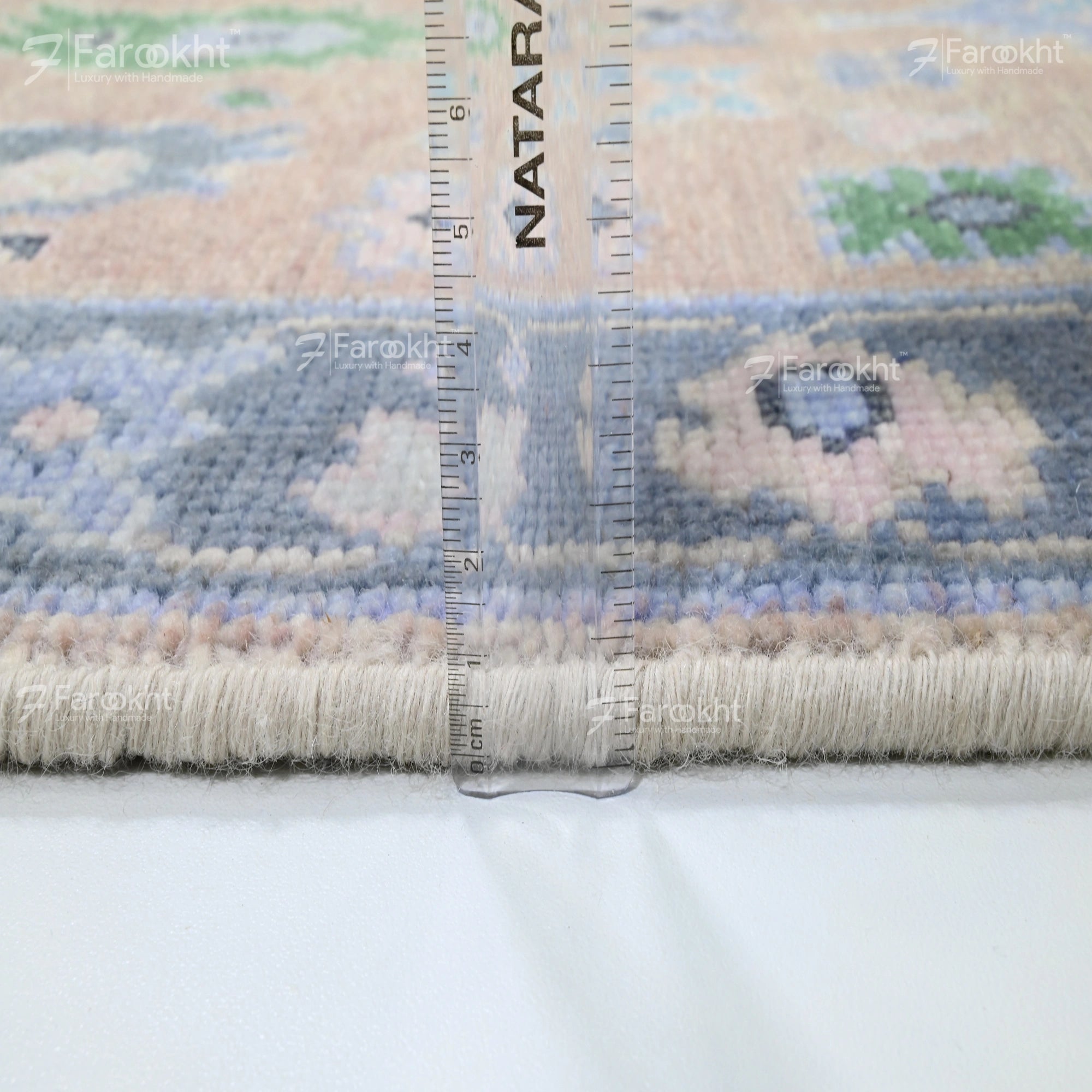 Rug with a ruler for scale on a white background, featuring the brand &