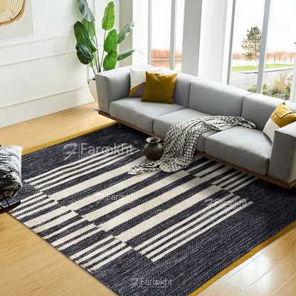 Modern living room with a gray sectional sofa, striped rug, and decorative elements.