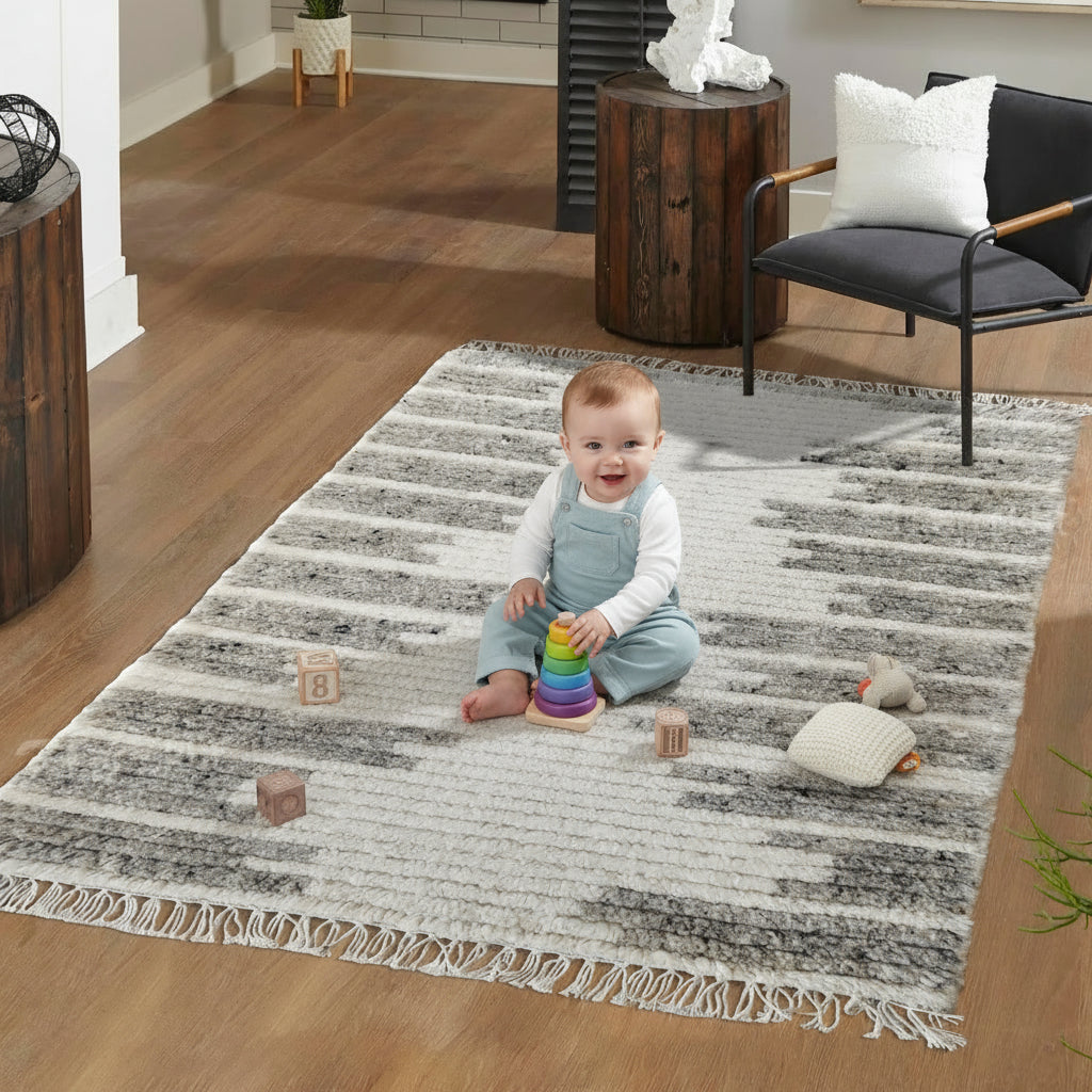 Baby playing on a striped rug in a living room