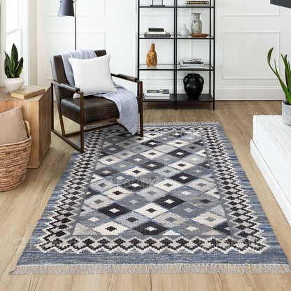 Patterned rug on a wooden floor with a chair and shelves in the background