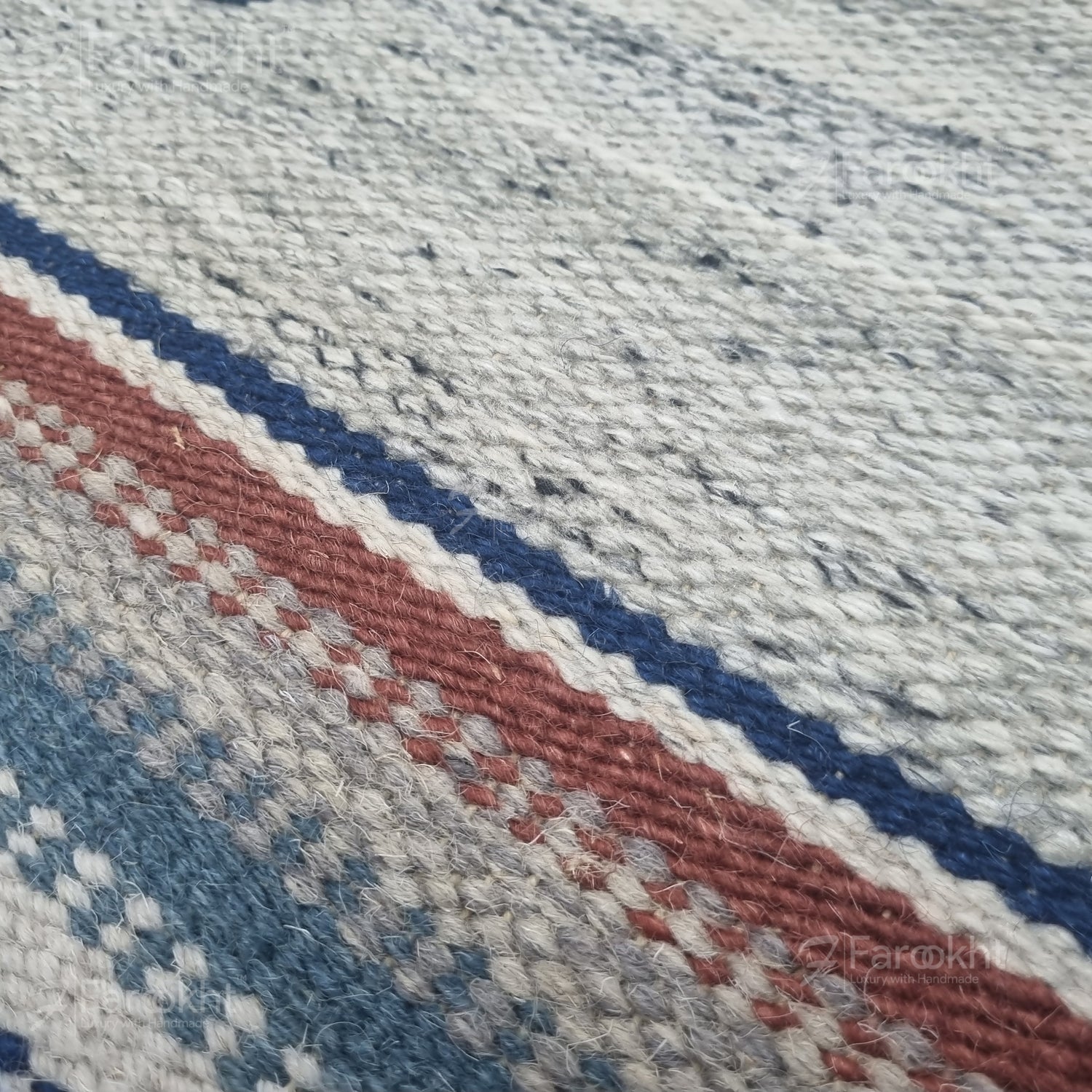 Close-up of a textured fabric with red, blue, and gray stripes.