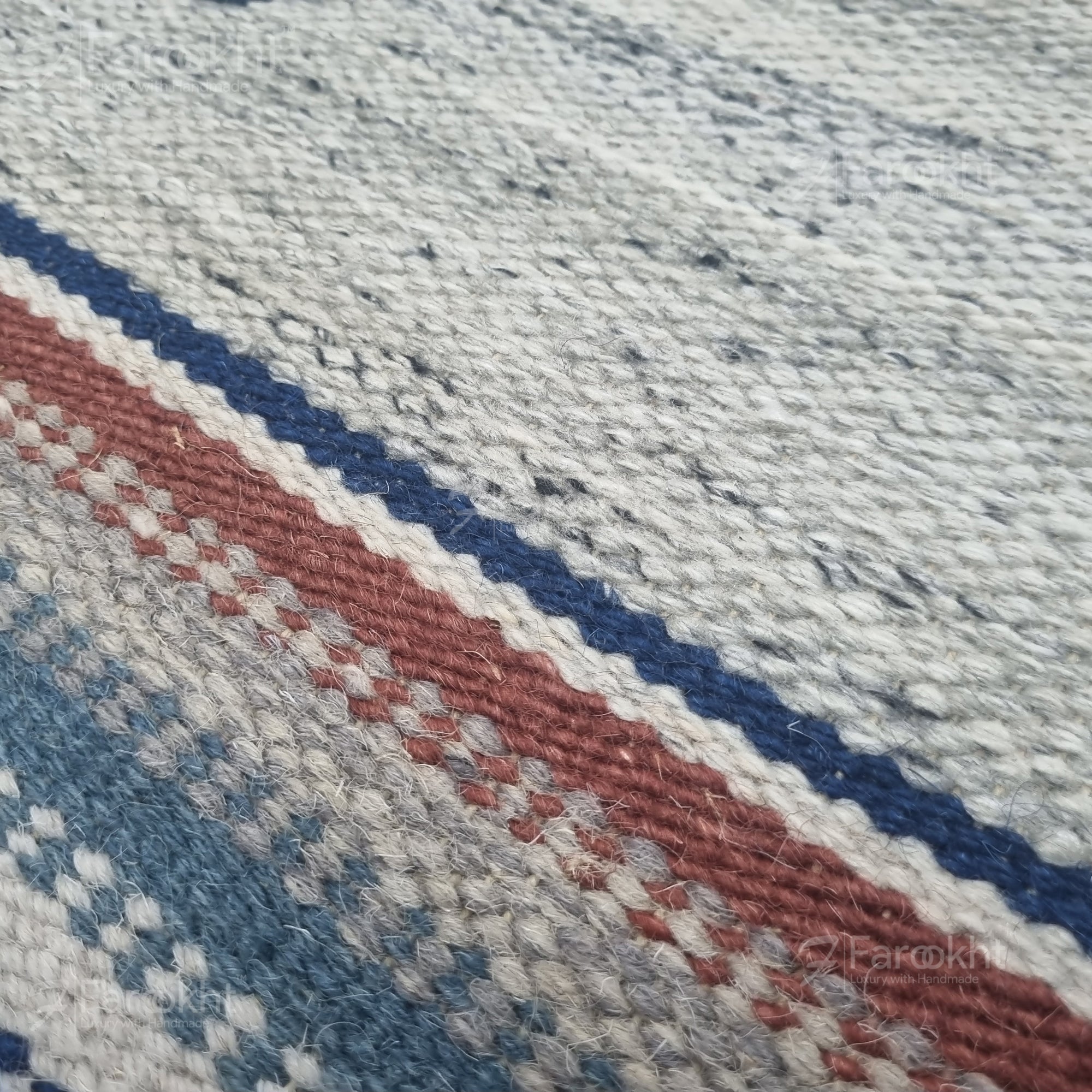 Close-up of a textured fabric with red, blue, and gray stripes.