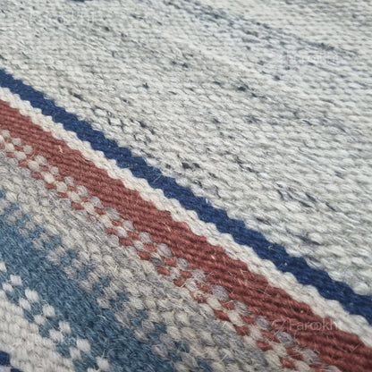 Close-up of a textured fabric with red, blue, and gray stripes.