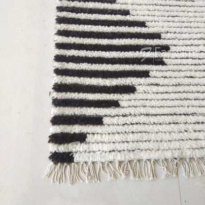 Black and white striped rug with fringe on a light gray floor