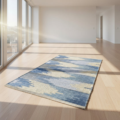 Blue and beige patterned rug on a white floor