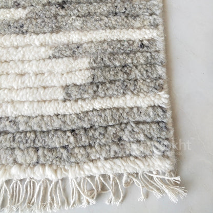 Textured rug with white and gray stripes on a light background