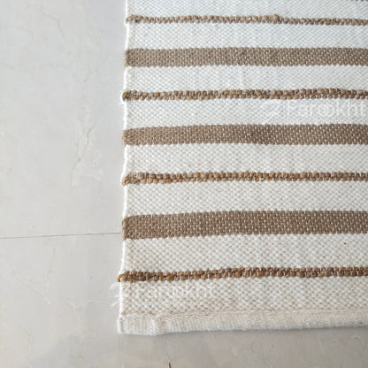 Striped rug with brown and beige stripes on a light gray floor
