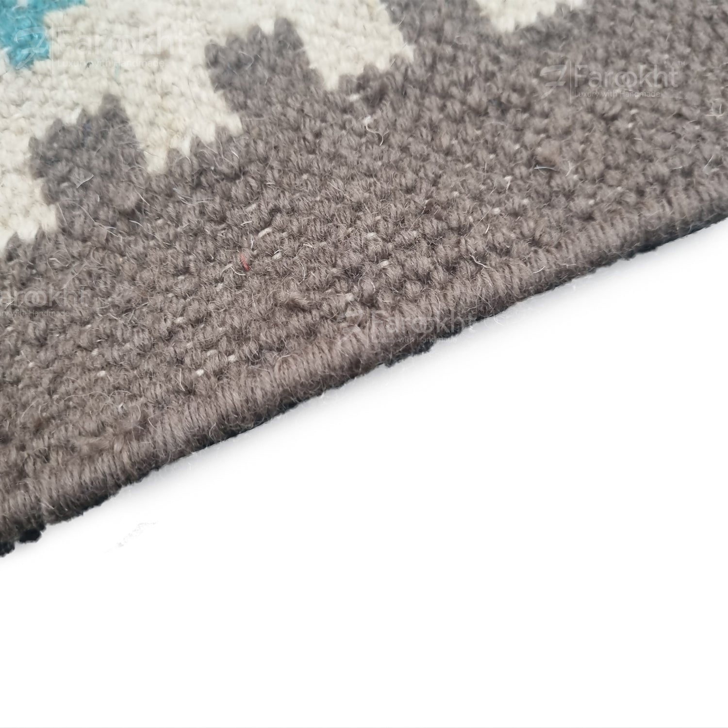 Close-up of a textured gray rug corner on a white background