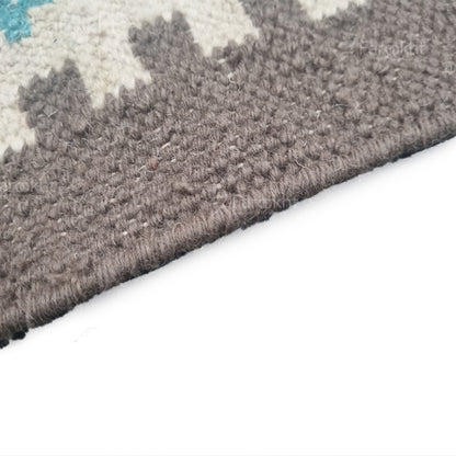 Close-up of a textured gray rug corner on a white background