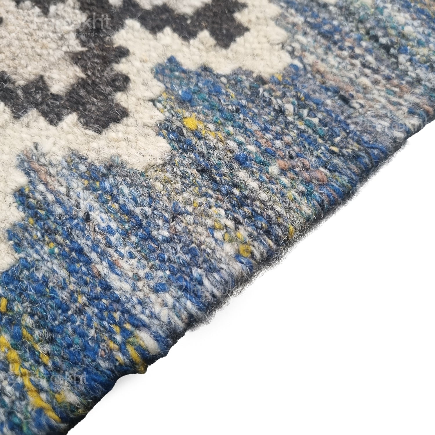 Close-up of a textured rug with blue, gray, and white pattern on a white background