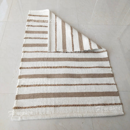 Striped rug with brown and white stripes on a light gray floor.