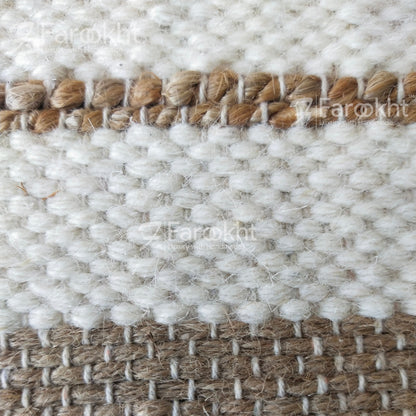 Close-up of a woven textile with white and brown patterns, branded &