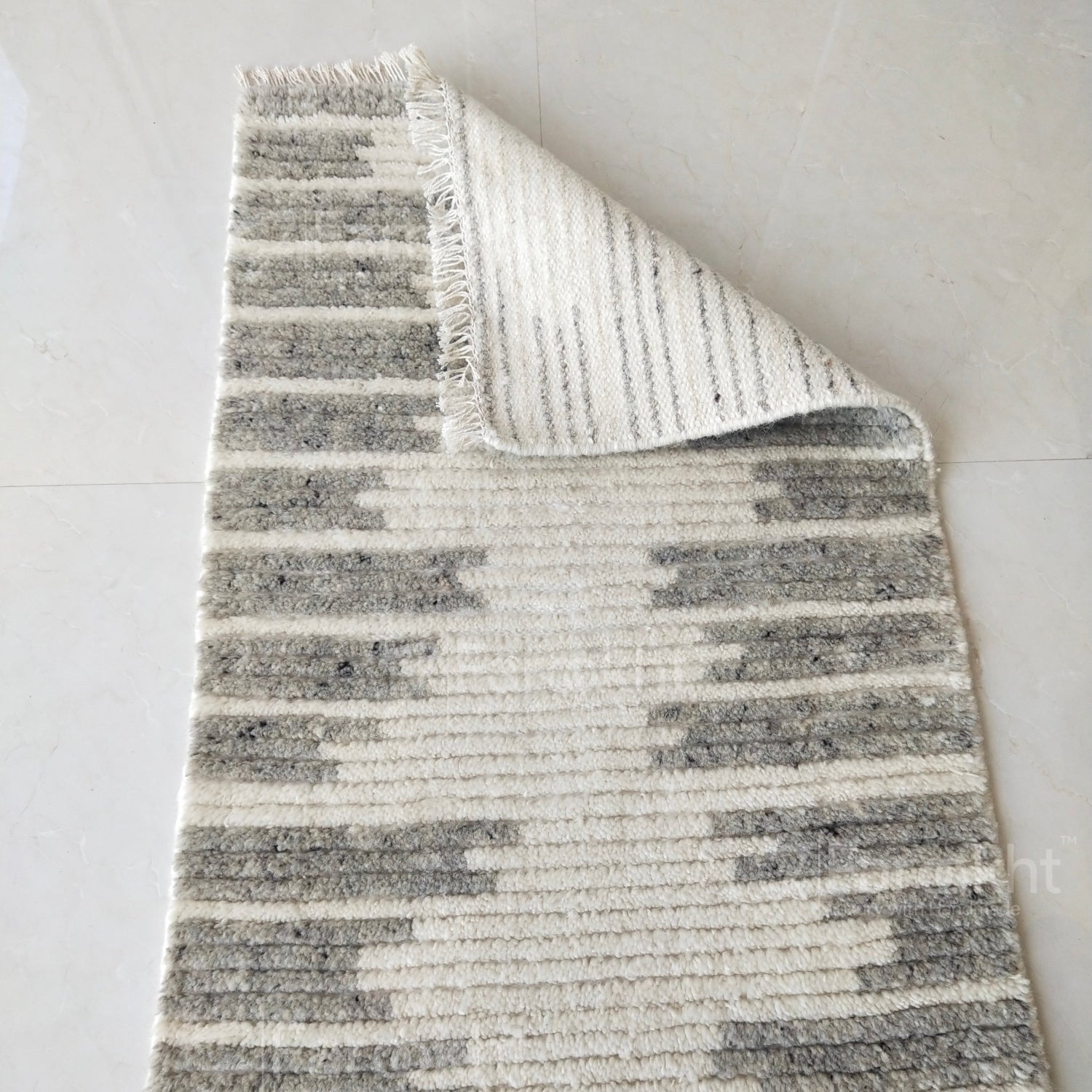 Gray and white striped rug on a light gray background