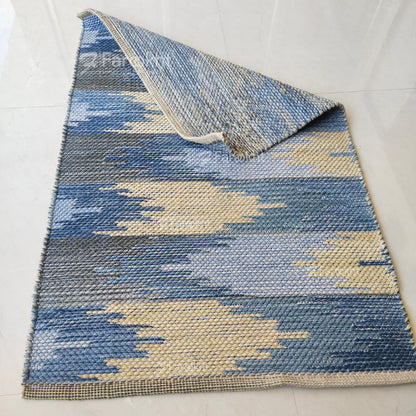 Blue and beige patterned rug on a white floor