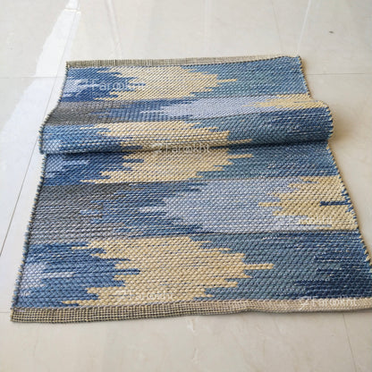 Blue and beige patterned rug on a white floor
