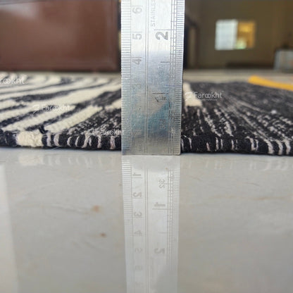 Rug with a ruler showing measurements on a marble floor.