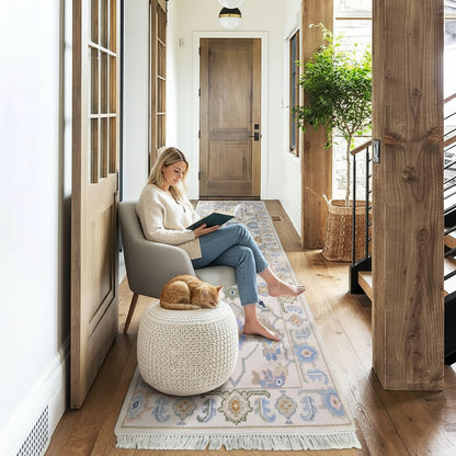 Long decorative rug on a wooden floor with a wooden door and plant in the background
