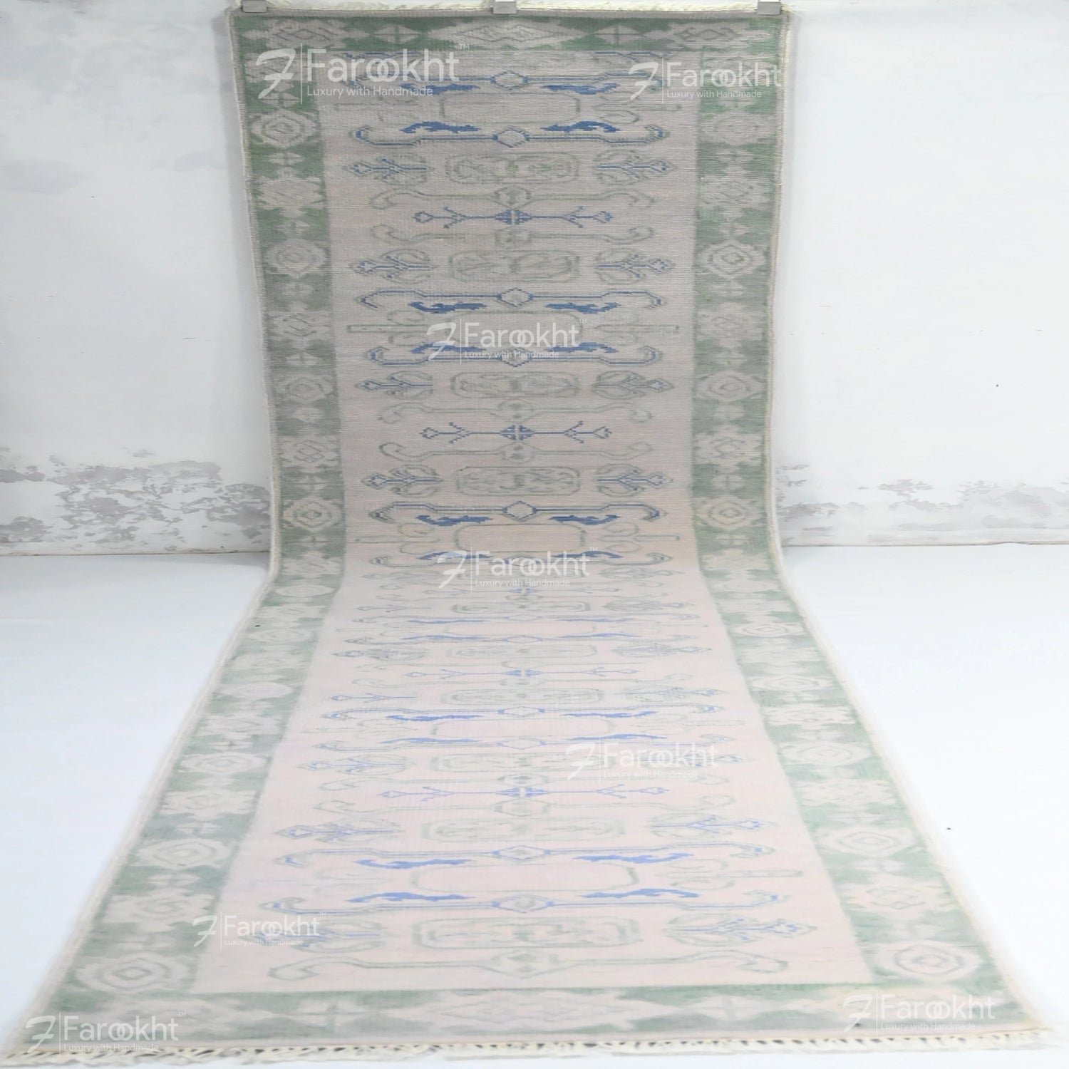 Decorative rug with a geometric pattern on a white background, branded &