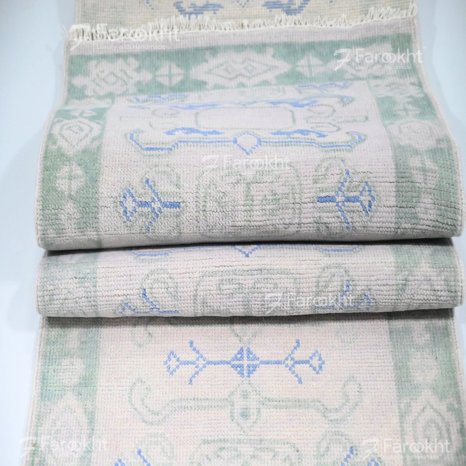 Stack of folded towels with geometric patterns on a light blue background