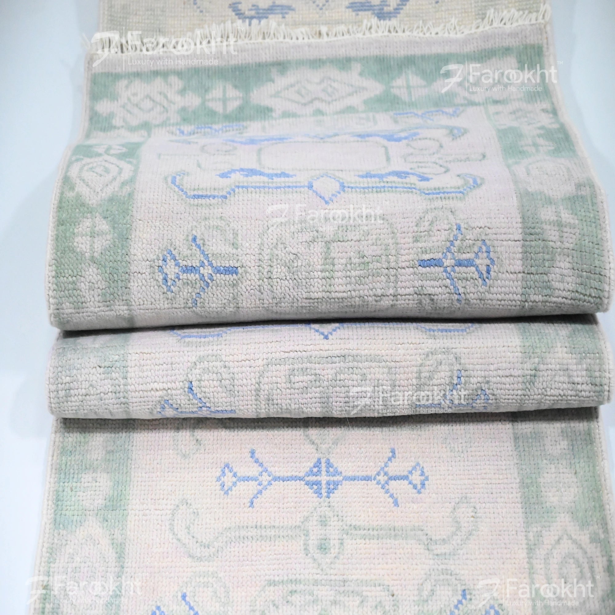 Stack of folded towels with geometric patterns on a light blue background