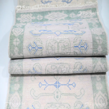 Stack of folded towels with geometric patterns on a light blue background