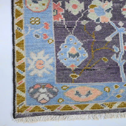 Elegant wool blend hand-knotted rug featuring blue border and intricate floral motifs
