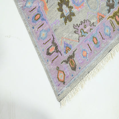 light grey soft rug with pastel border patterns