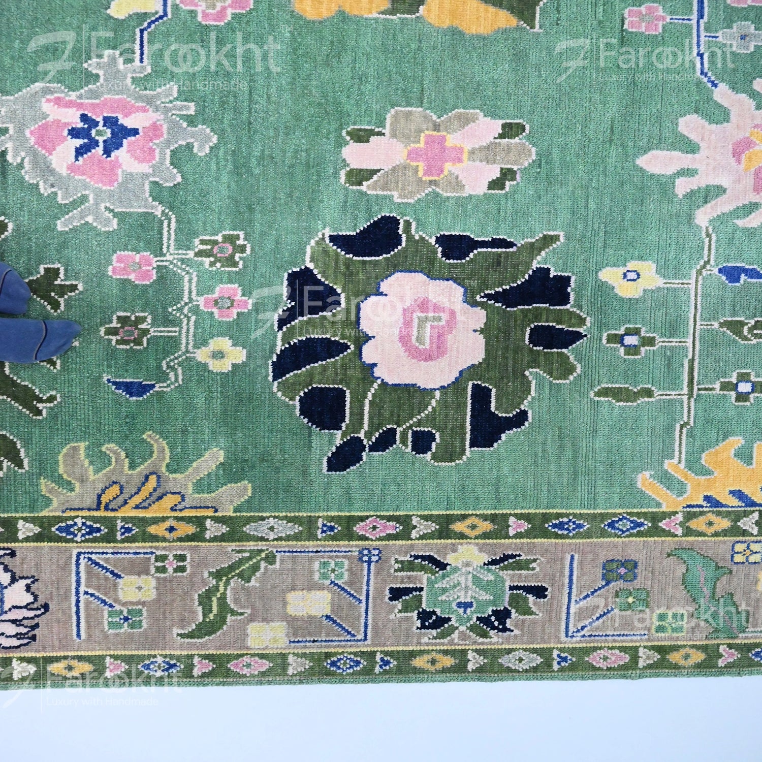 Close-up of a floral patterned rug with green background