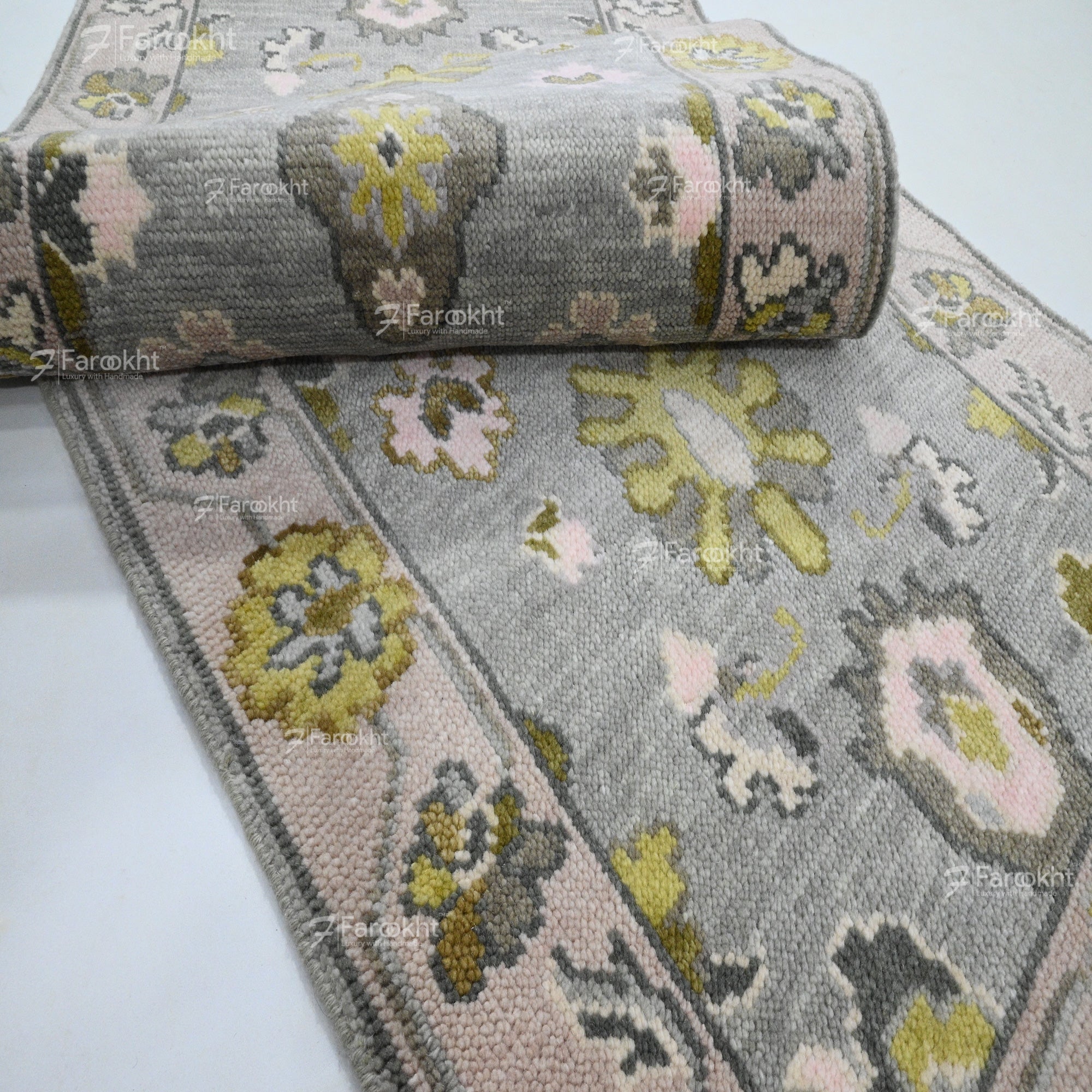 Roll of patterned rug with floral design on a white background