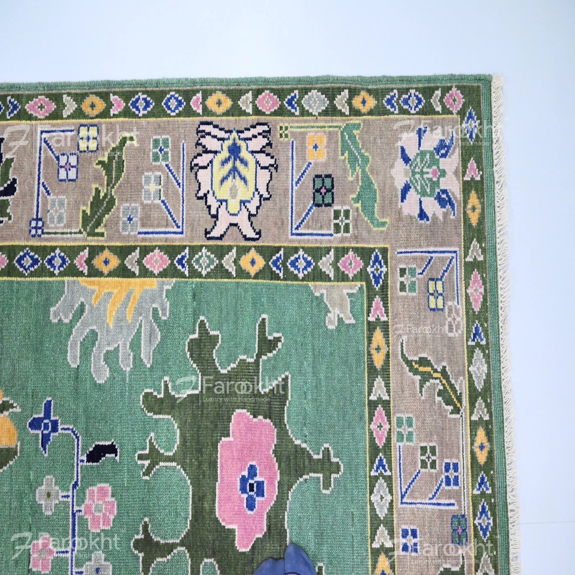 Close-up of a colorful patterned rug with geometric and floral designs on a light blue background.