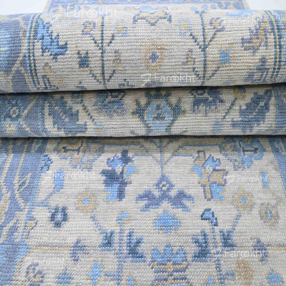 Stack of blue and beige patterned rugs with &