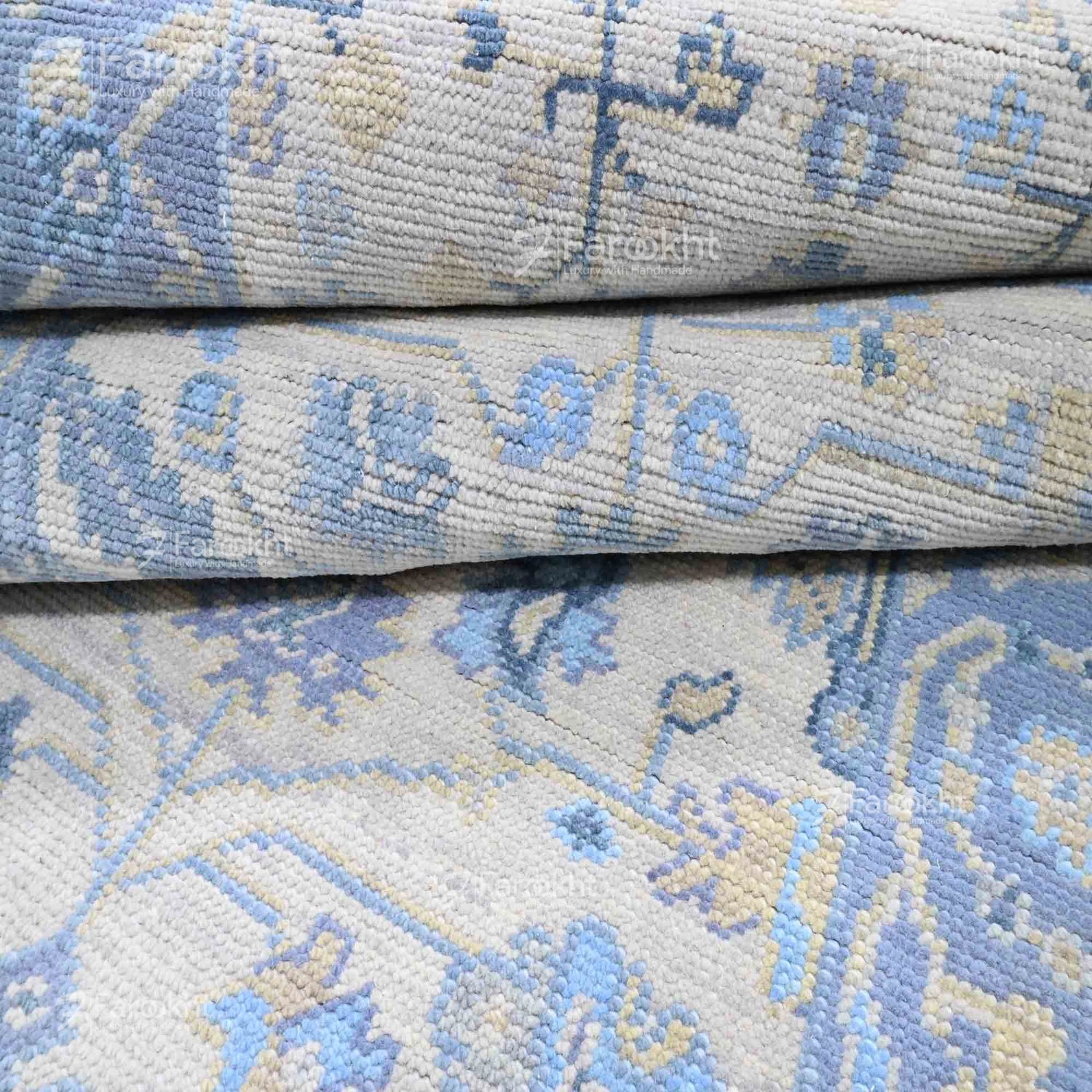 Close-up of a patterned rug with blue and beige colors.