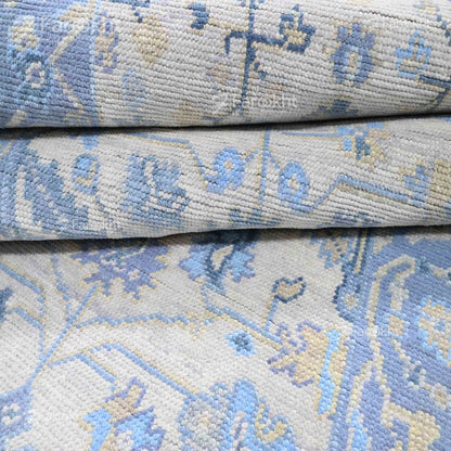 Close-up of a patterned rug with blue and beige colors.