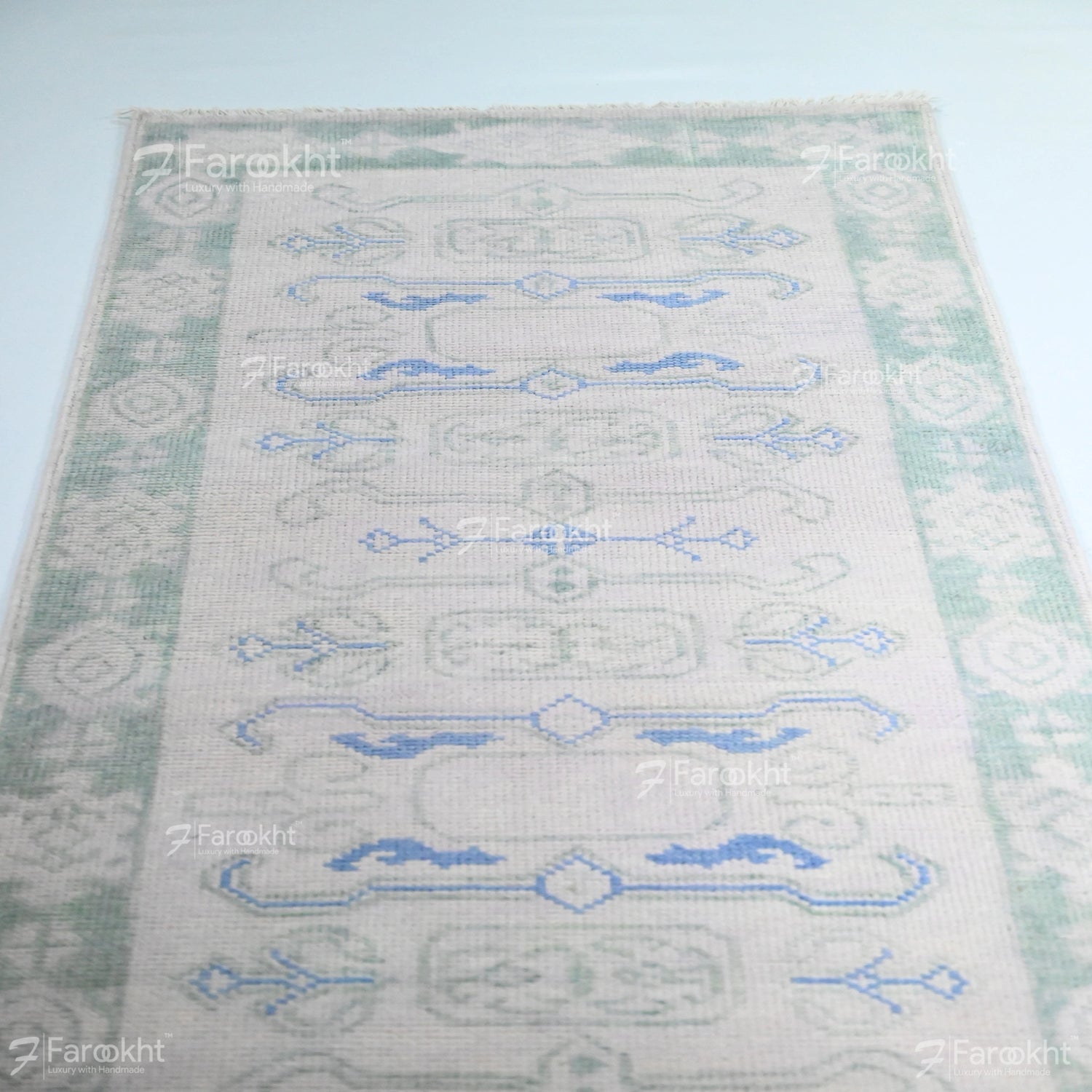 Patterned rug with blue and green design on a light background
