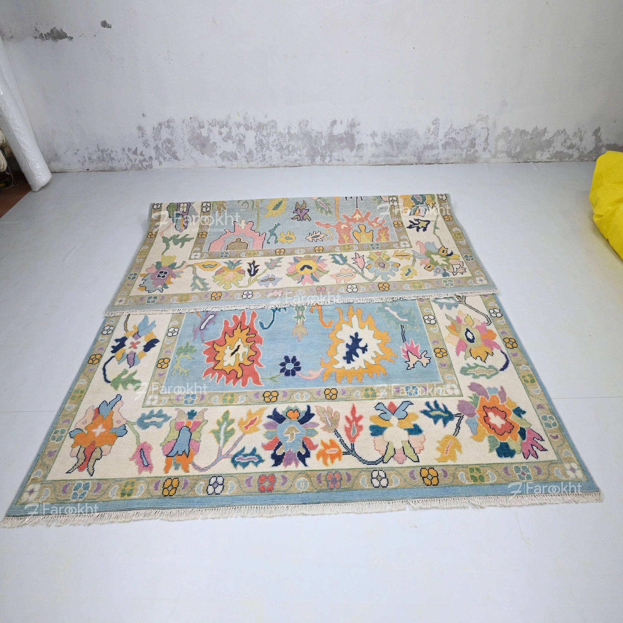 Colorful patterned rug on a white floor with a textured wall background
