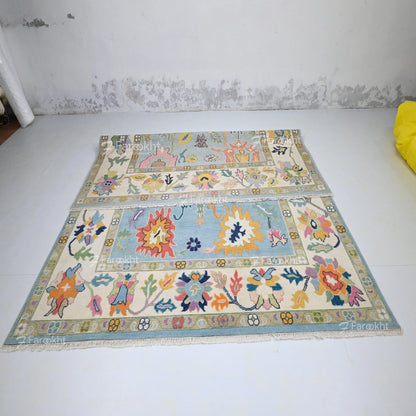 Colorful patterned rug on a white floor with a textured wall background