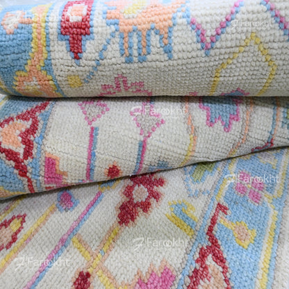 Close-up of a patterned fabric with colorful designs, featuring the brand &