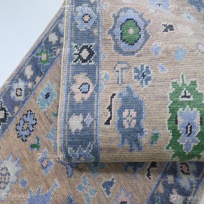 Close-up of a patterned rug with floral designs in blue, green, and beige.