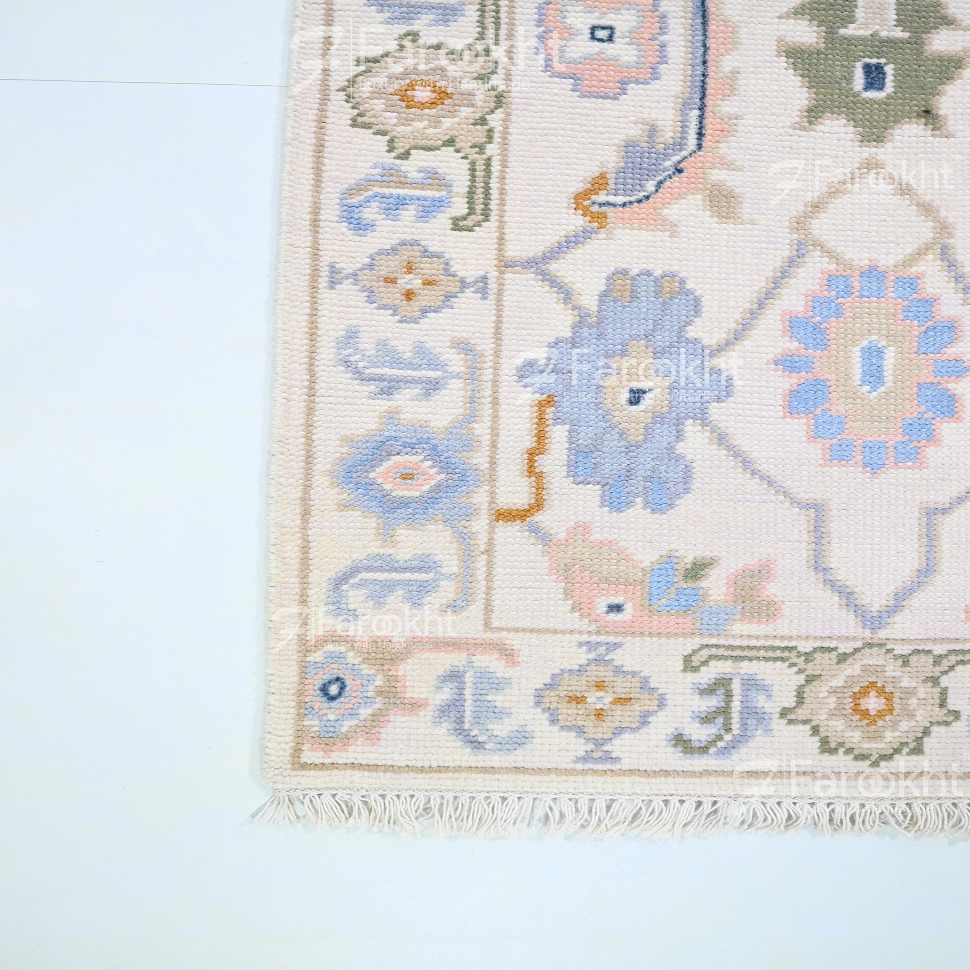 Close-up of a patterned rug with geometric designs on a light blue background