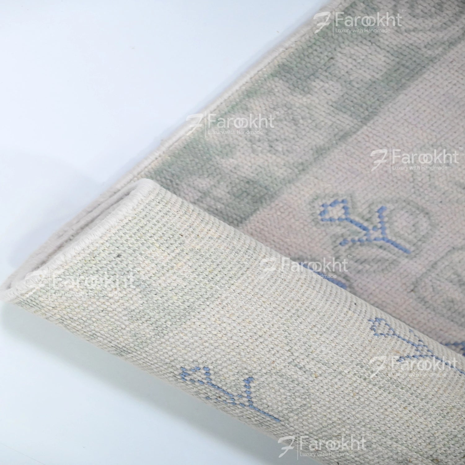Close-up of a textured fabric with embroidered designs on a white background, featuring the brand &