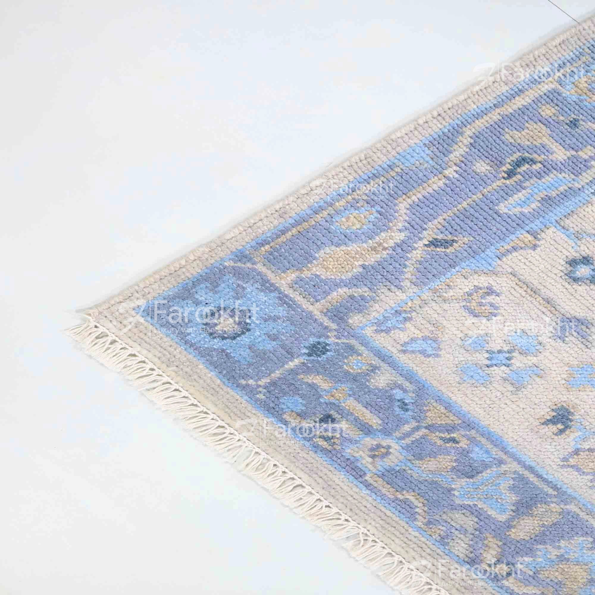Blue and beige patterned rug on a white floor